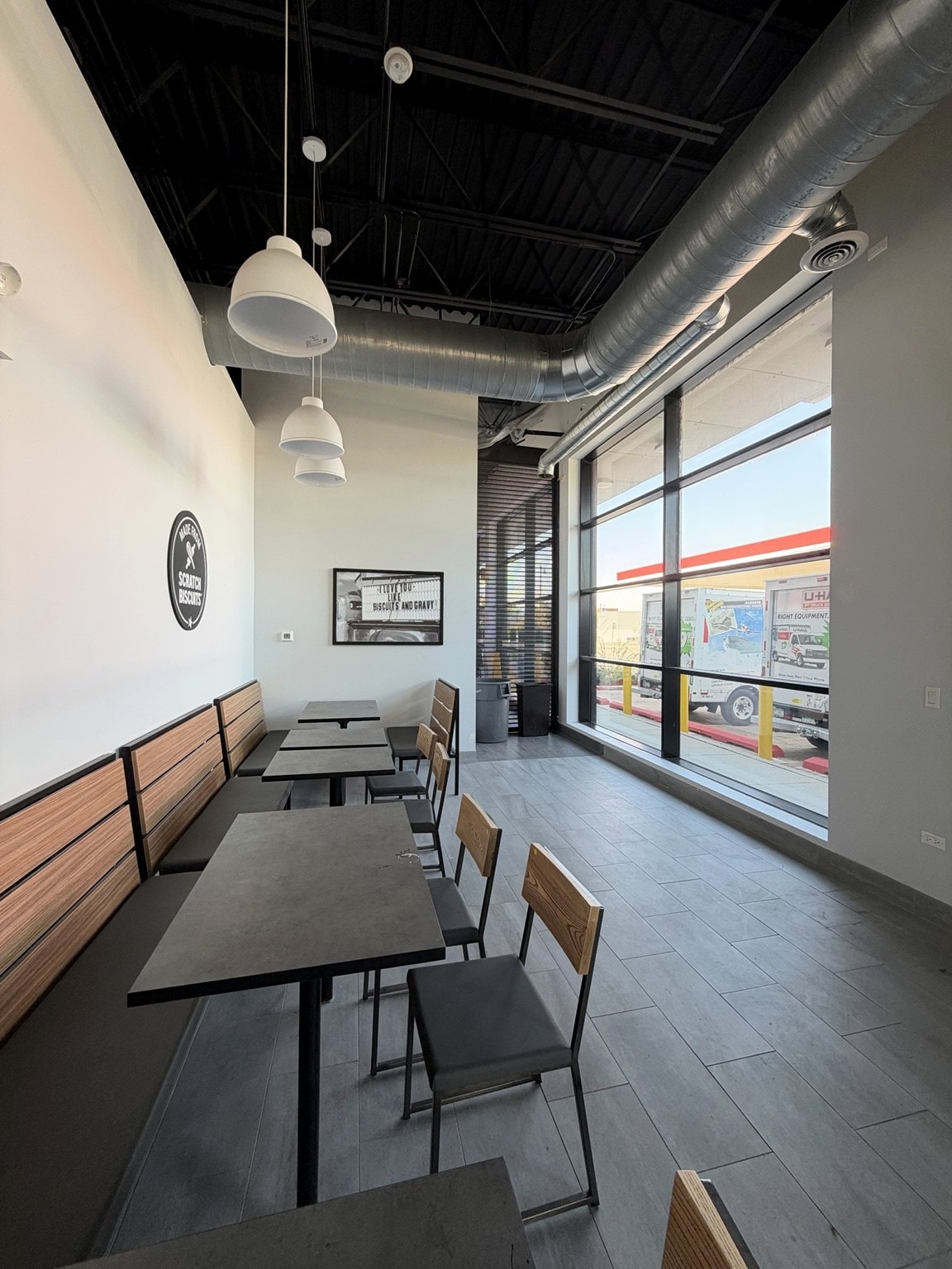 Customer dining area with pendant lighting and storefront windows
