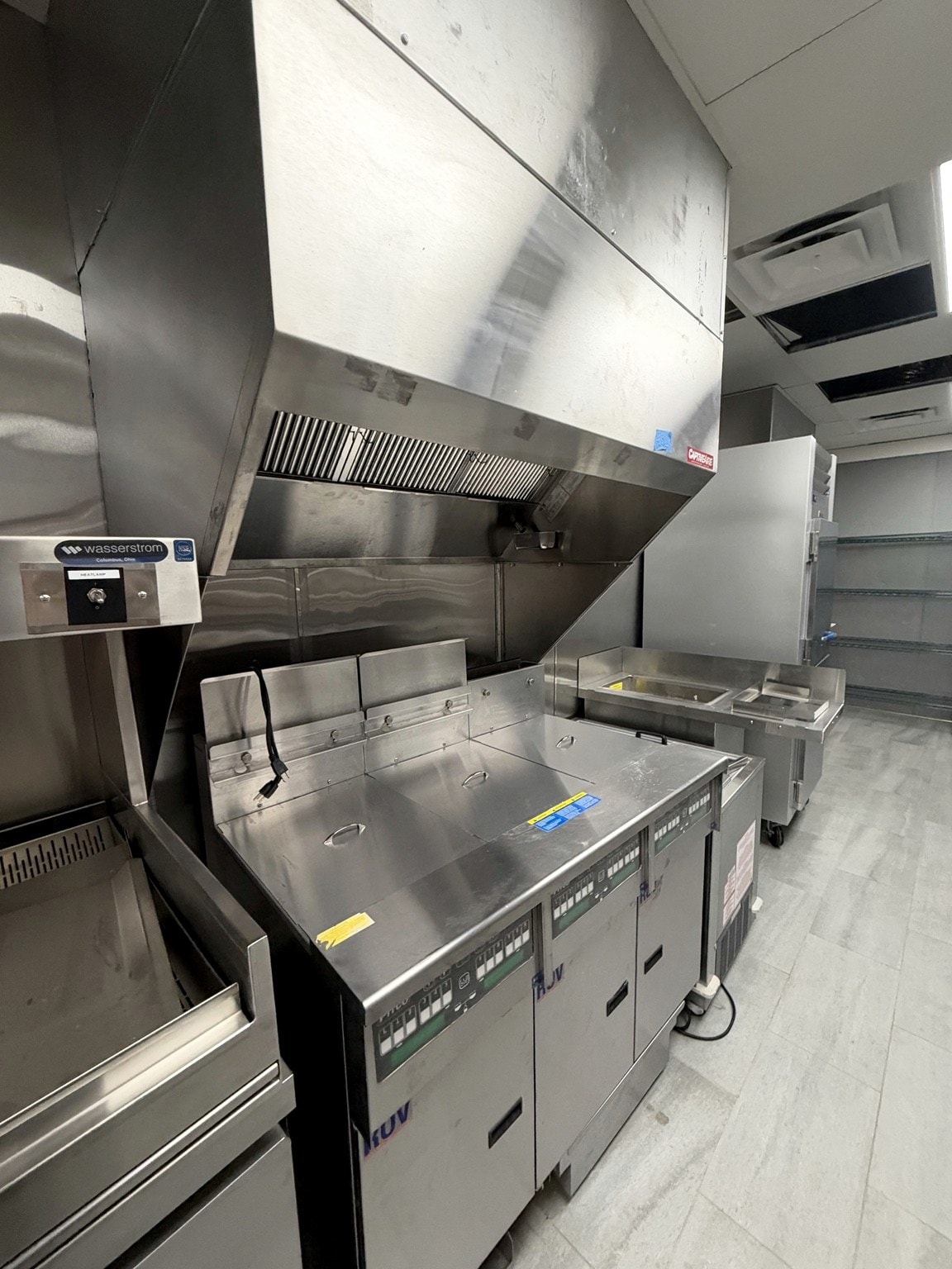 Commercial cooking line with fryers and ventilation hoods