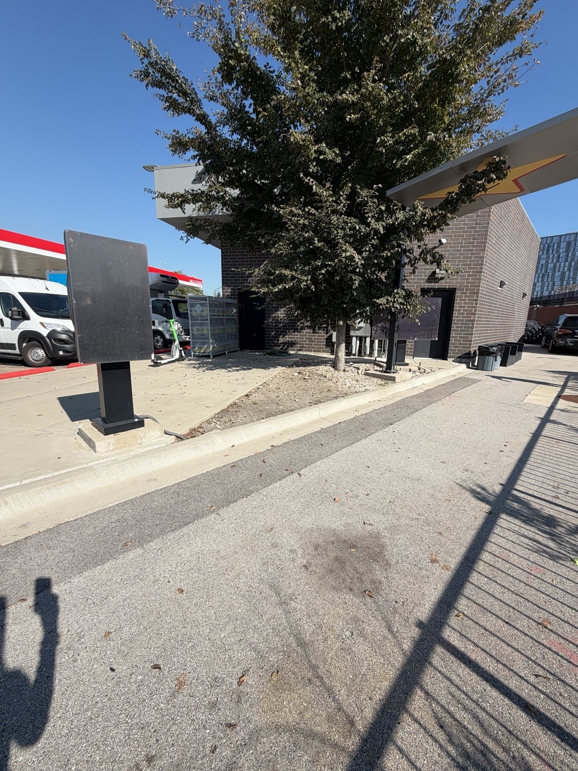 Building exterior from drive-through approach, brick facade and order kiosk